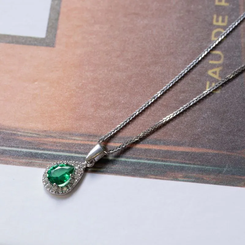 White gold drop necklace with white zircons and a green zircon in the center